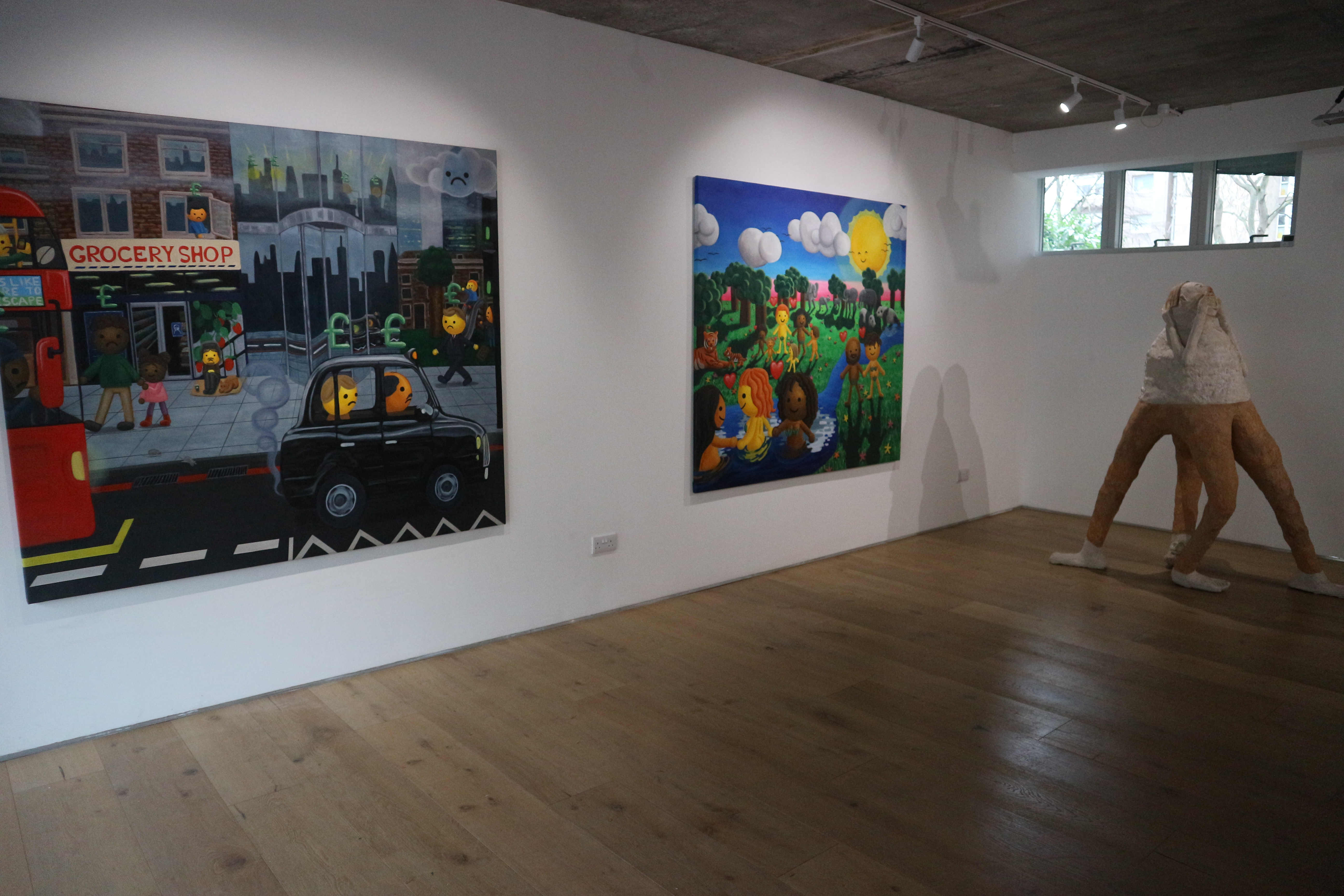 Two large paintings are hung on a white wall next to each other. The left is a gloomy cartoonish london scene, and the right is a happy sunny landscape with smiling characters in the same style. A tall humanoid-like sculpture is to the right.