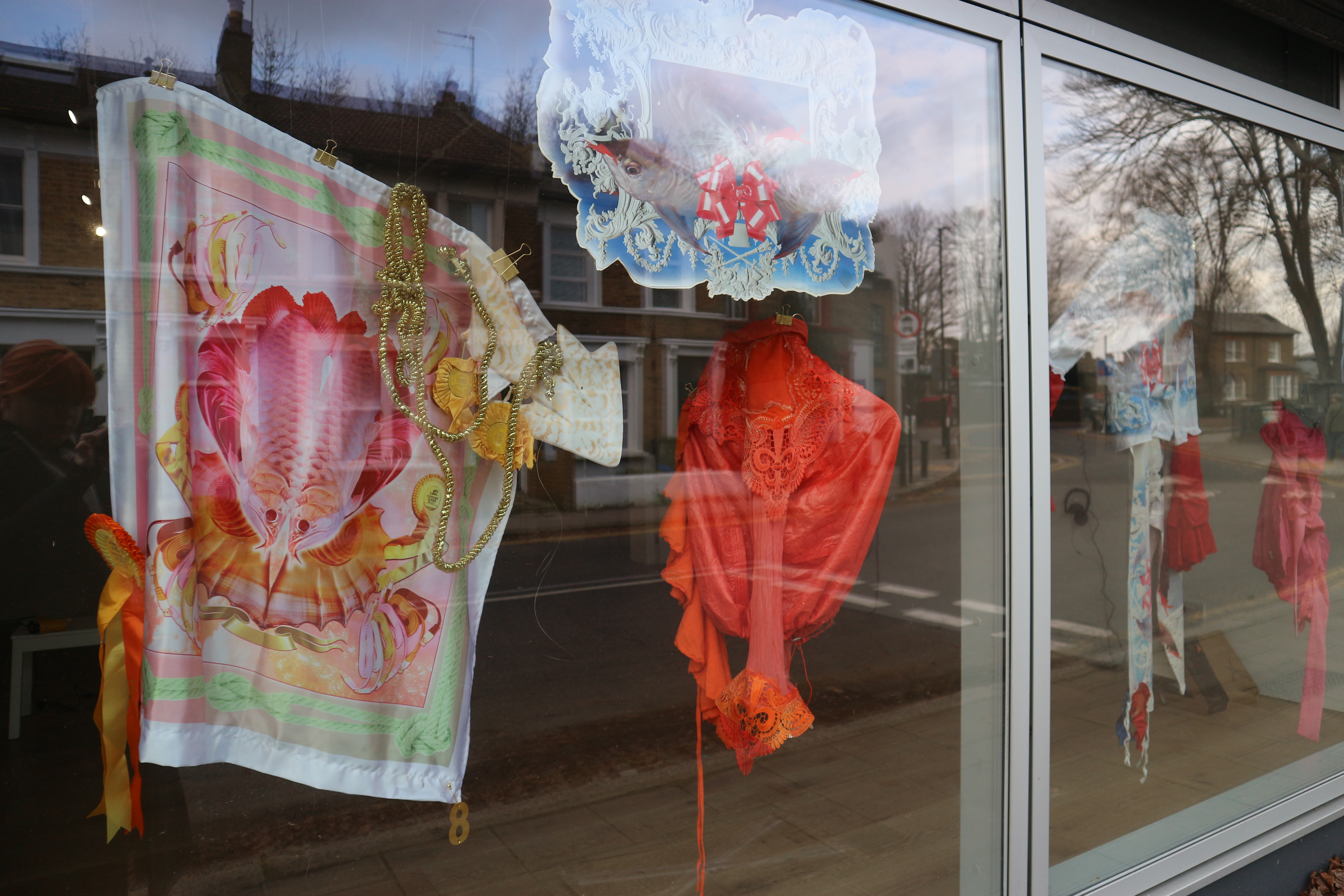Photo of a brightly coloured textile installation in a gallery window.